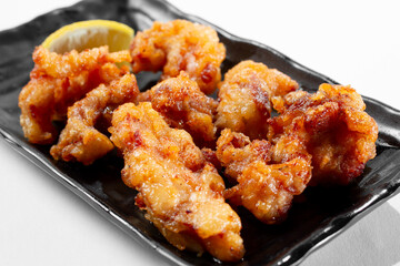 A view of a plate of deep fried fish bites.