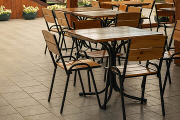 Outdoor Cafe Seating with Wooden Chairs and Tables on a Sunny Day