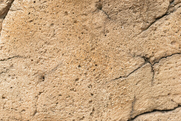 Detailed Close-Up of Beige Stone Texture with Natural Cracks and Rough Surface