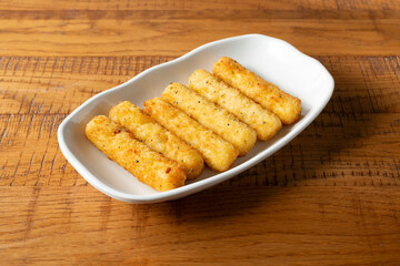 A view of a plate of mozzarella cheese sticks.