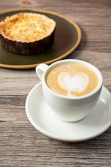 A closeup view of a small mug of cortado and a quiche.