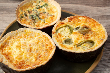 A view of a variety of quiche on a plate.