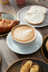 A view of a coffee latte cup among other breakfast entrees.