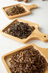 A view of assorted loose leaf tea on bamboo saucers.