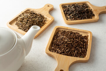 A view of assorted loose leaf tea on bamboo saucers.