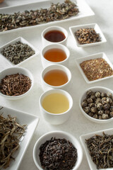 A view of assorted loose leaf tea and tea liquor.