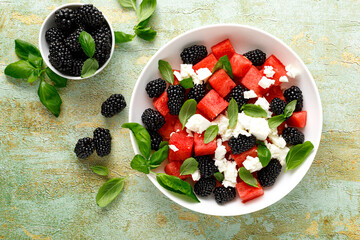 Watermelon salad with feta cheese, blackberry and fresh basil, top view