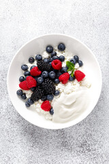 Cheese cottage with yogurt and fresh berries. Curd with blueberry, raspberry and blackberry, top view