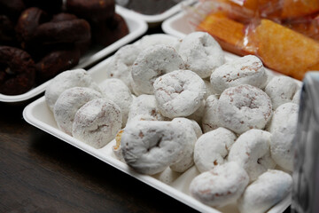 A view of a tray of powdered donuts.