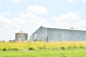 Metal Barn and Grain Bin in a Farm Field