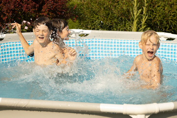 A boy with wet hair is enthusiastically swimming in a pool, giving a thumbs-up gesture. Another...
