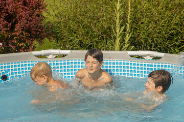 A boy with wet hair is enthusiastically swimming in a pool, giving a thumbs-up gesture. Another...
