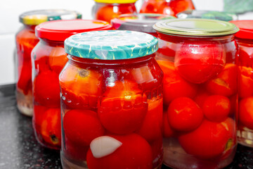 Red ripe tomatoes in glass jars. Salting and pickling vegetables for the winter
