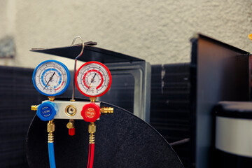 Close up of manifold gauges used for checking air conditioner refrigerant in need of maintenance....