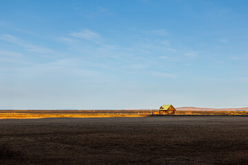 Fototapeta premium Scandinavian farmland with vast fields and lovely residences next to mountain peaks. Amazingly stunning hills forming scenery with lands, icelandic valleys and idyllic surroundings.