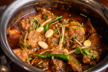 mutton Qorma topped with almonds ginger and green chilli