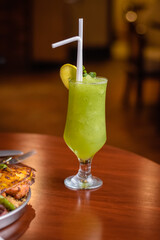 Fresh mint margarita served in glass with lemon slice and straw 