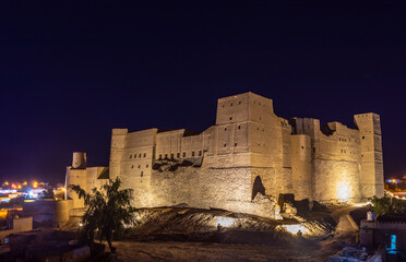 Bahla stronghold fortress stone walls illuminated at night, Bahla, Oman