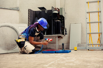 Competent mechanic preparing for yearly condenser maintenance. Trained repairman unpacking toolset box with professional gear needed to mend damaged air conditioner internal components