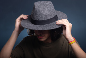 Close-up portrait of handsome young man wearing gray colored hat and posing for photo.