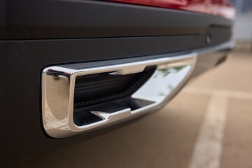 Detailed view of cars exhaust system, grille, hood, bumper, and design