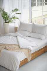 Bed in a bright room. A place to relax.