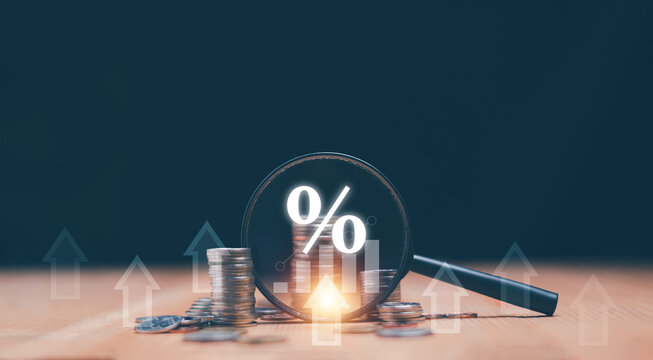 Coins moneys stacked and have magnifying glass with graph and percentage symbol inside. Finance and business growth concept. Financial increase interest rate or mortgage investment dividend.