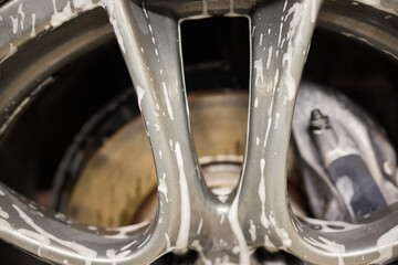 Detailed view of a car wheel rim being cleaned with foam for maintenance and shine