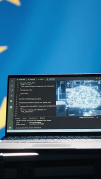 Vertical video AI technology used by European Union alliance to combat illegal bot accounts on social media. Artificial intelligence algorithms detecting fake news running on laptop in EU command