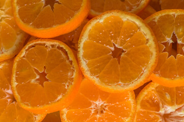 Fresh, juicy tangerine slices or tangerines with leaves as a background