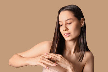 Young dark-haired woman on beige background