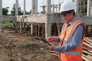 A team of engineers inspects beam work and installs concrete pillars according to the blueprint.