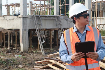 A team of engineers inspects beam work and installs concrete pillars according to the blueprint.
