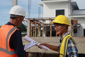 A team of engineers inspects beam work and installs concrete pillars according to the blueprint.