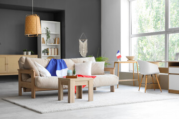 Interior of living room with French flags, sofa and tables