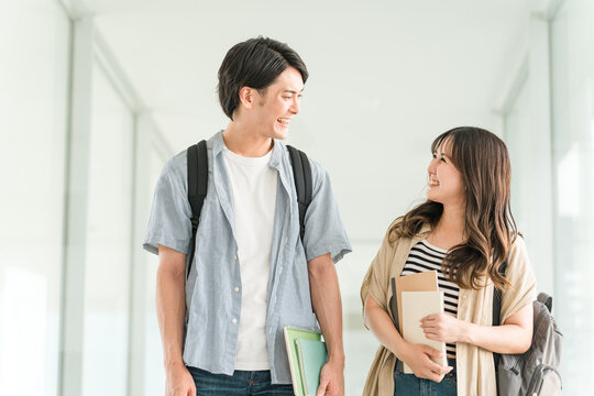 大学・短大・専門学校の校舎・キャンパスを歩く男女カップル・同級生の学生
