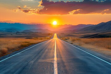 Fototapeta premium A deserted road stretching straight into the horizon with a stunning sunset and mountains in the background