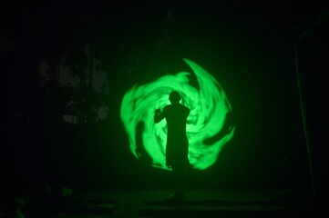 One person standing alone against a Colourful circle light painting as the backdrop