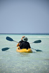 Tourists canoeing on a tropical beach with water as clear as silk, an inspiring holiday on a tropical beach, with views of the sea and sand as white as silk