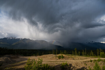 Beautiful summer storm over the rocky mountains with Rainbow