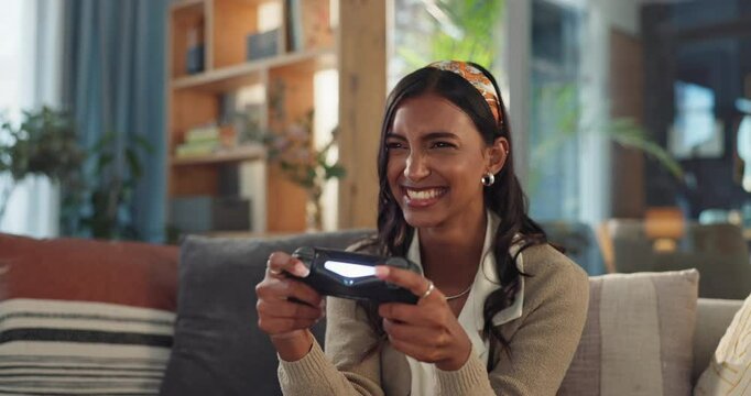 Excited woman, relax and playing games with controller for winning, victory or achievement on sofa at home. Young female person, winner or competitive girl enjoying fun console entertainment at house