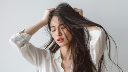 Naklejka premium Young woman with long hair pulling her head in pain, feeling stressed and depressed