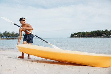 Happy Asian Man Enjoying Kayaking Adventure on Tropical Beach