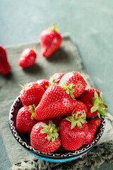 Bowl of Ripe Strawberries on Green Background with Napkin