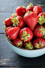 Strawberries in Ceramic Bowl on Dark Wooden Background, Close-Up