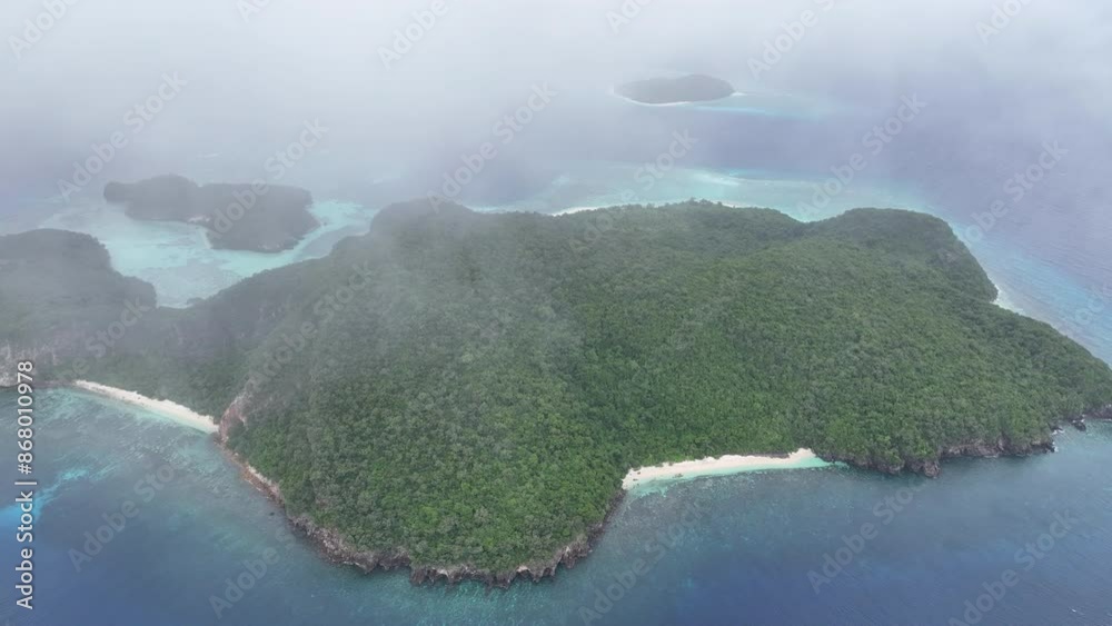 Wall mural Fast moving clouds drift over a remote and gorgeous tropical island, Pulau Tellang, not too far from Alor, Indonesia. This scenic region harbors spectacular marine biodiversity.