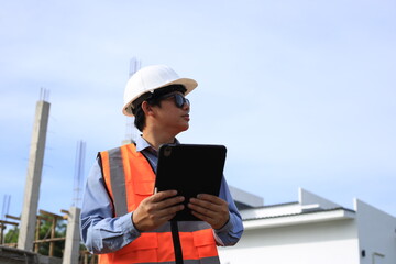 Young professional engineer in hat and blueprint paper is working...At the house construction site. Motivation: success, career growth. achieving goals