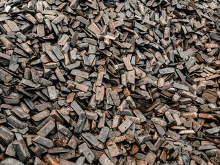 Transfer cast iron is cast iron used for further processing into steel. Pig iron ingots are stored in a warehouse. View of a stack of cast iron ingots stored in a warehouse at the seaport.