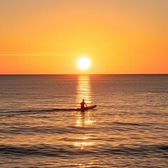 Fototapeta premium Silhouette of a surfer paddling out to sea, with the setting sun casting a warm glow on the ocean. The calm waves and expansive horizon evoke a sense of peace and adventure