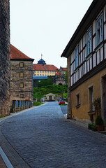 Fototapeta premium Kronach, Germany-April 10,2024:Scenic landscape view of street with ancient houses under red tile in the old town of Kronach. Typical architecture in Bavaria, region Upper Franconia, Germany